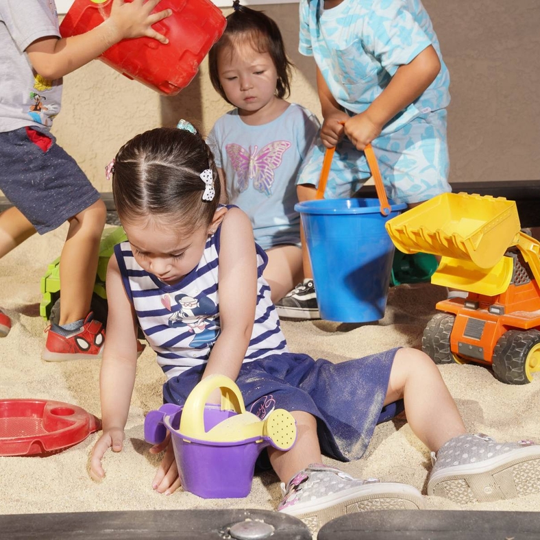 Children playing in the covered sandbox